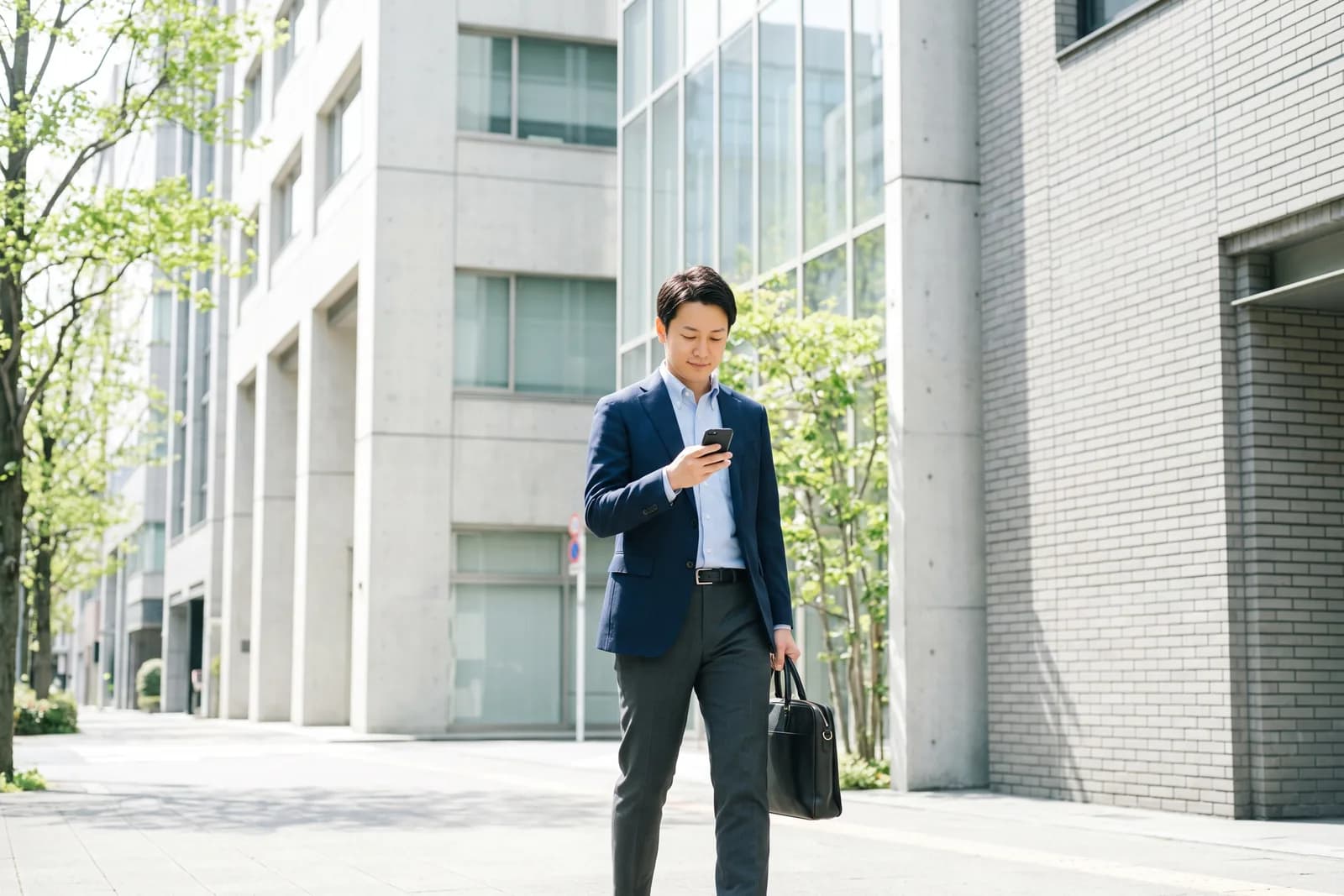 オフィス街の通りを歩くスーツ姿の会社員
