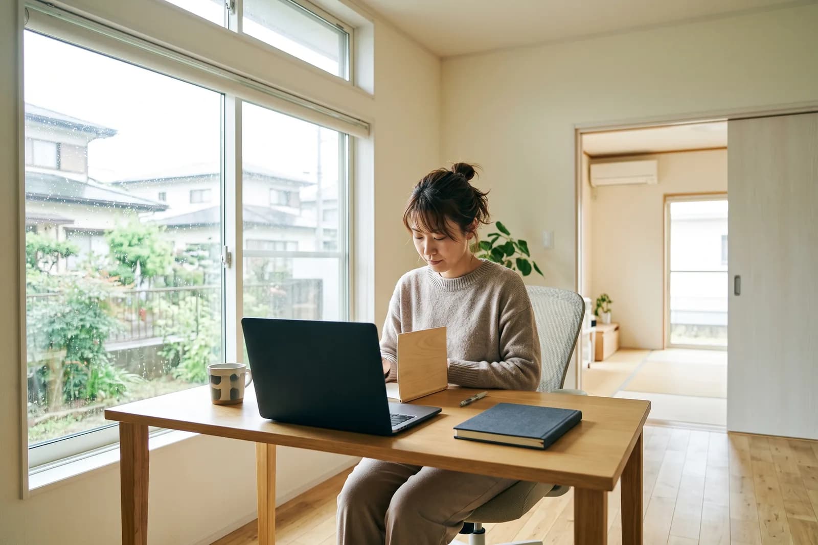 自宅の部屋で机に向かって開業の準備を進める人