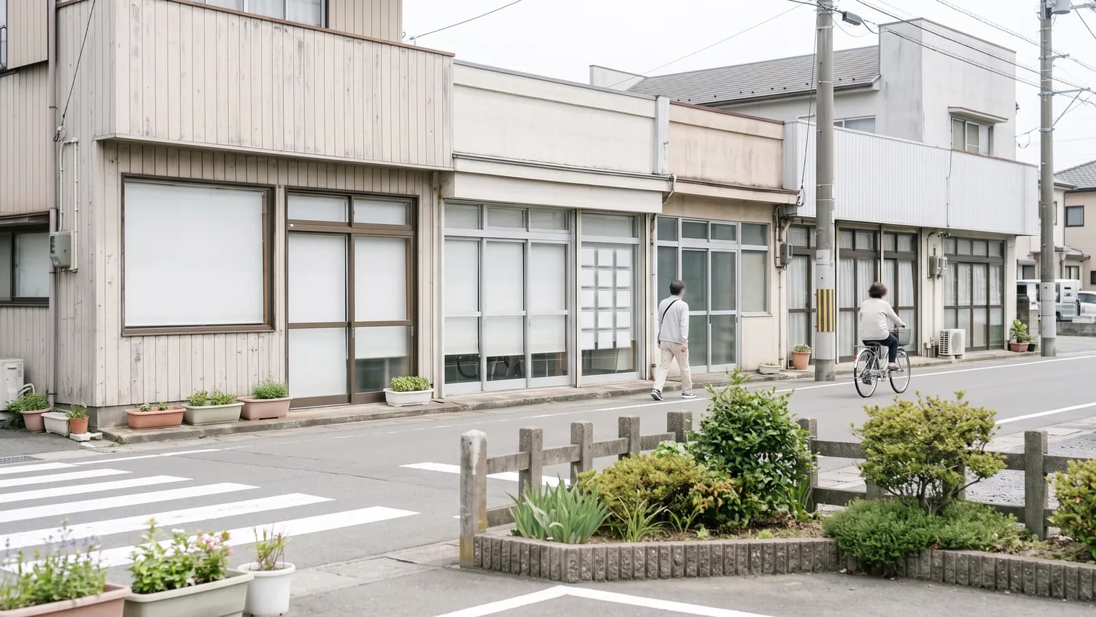 街の通りに面して建つ不動産店舗の並びと周囲の景色