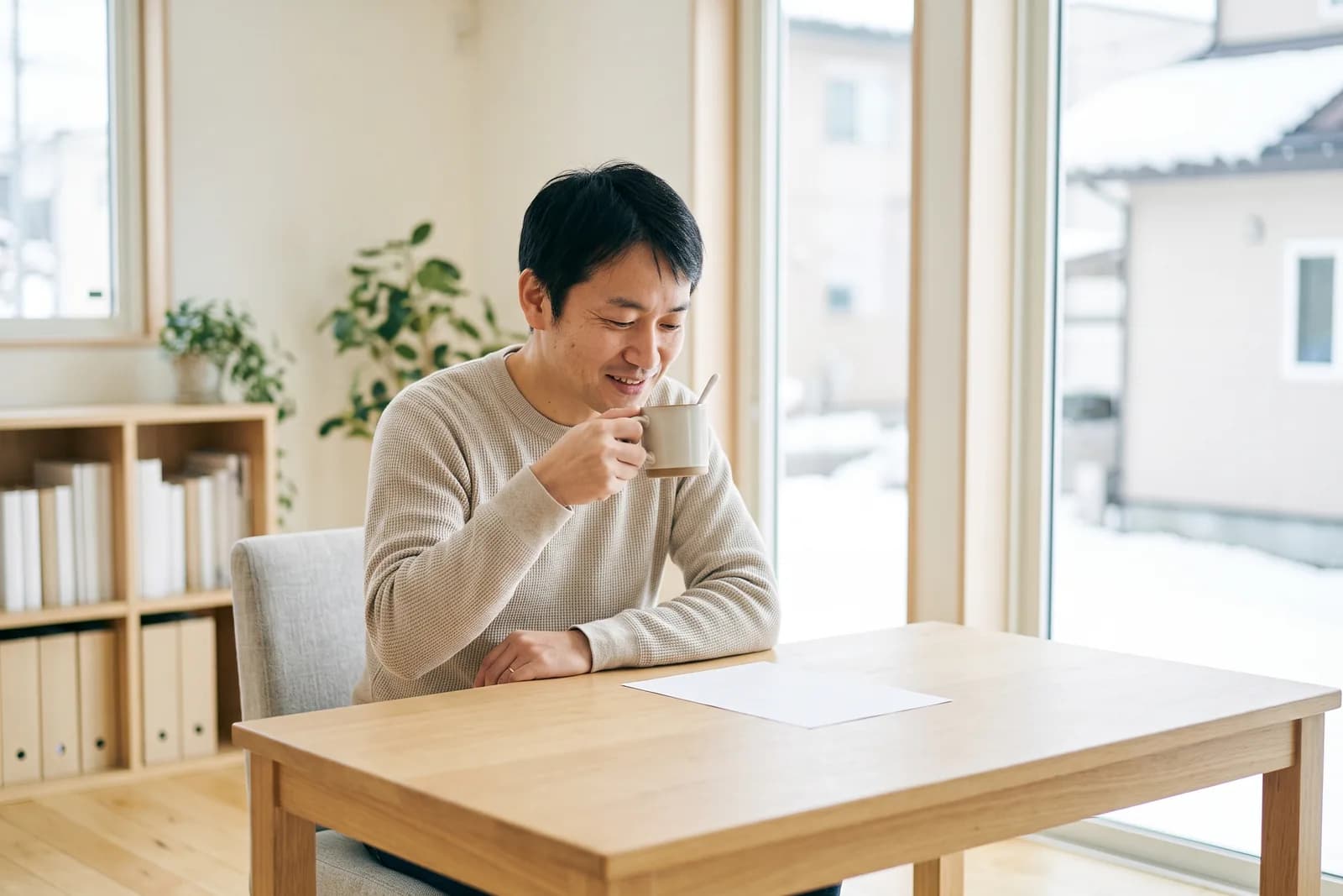 自宅の書斎で、宅建に合格した会社員がコーヒーを飲みながら一息ついている様子